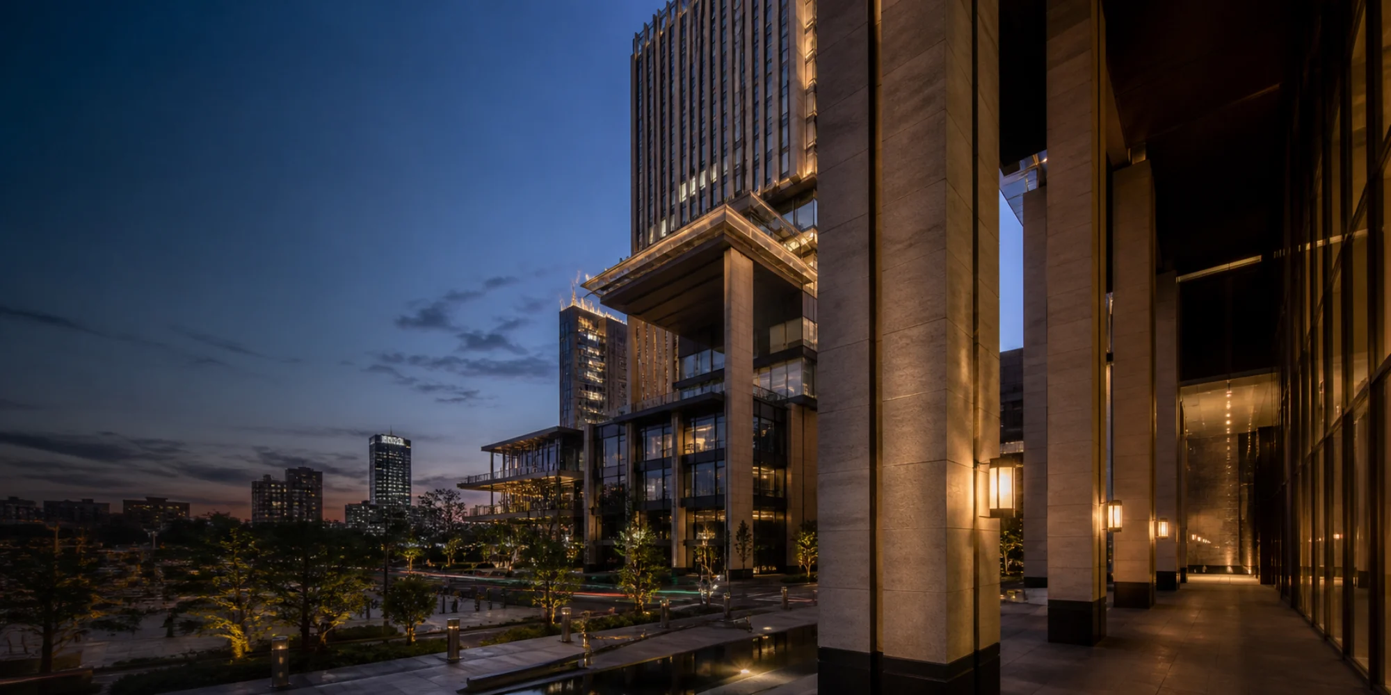 A landmark mixed-use development illuminated at blue hour